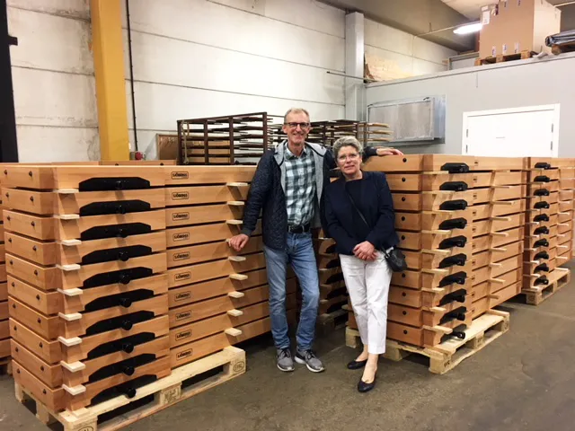 En man och kvinna står i ett lager framför ett flertal träpallar